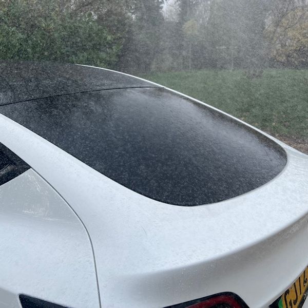 Tesla Model Y, white, in heavy rain, rear windscreen and tailgate